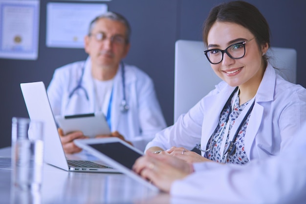 Equipe médica séria usando um laptop em um escritório bem iluminado