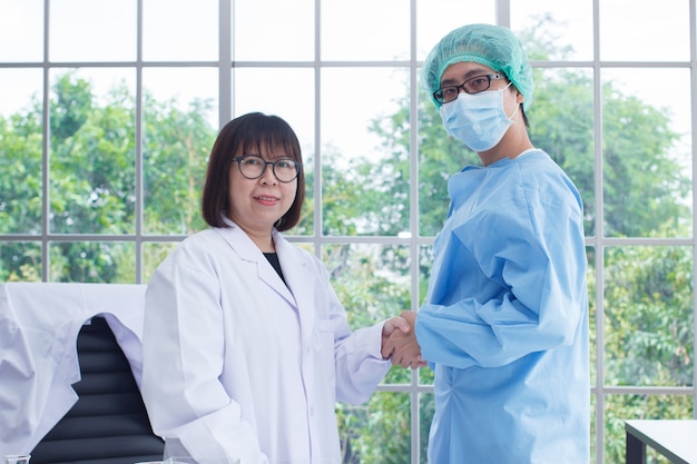 Equipe médica usar handshaking de forma branca e azul no laboratório