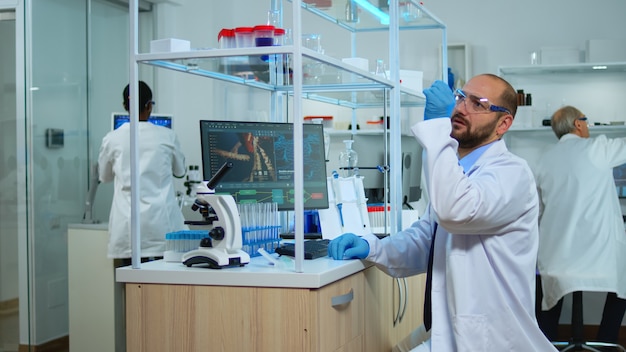 Equipe multiétnica de cientistas trabalhando em laboratório médico, desenvolvendo medicamentos inovadores. laboratório modernamente equipado e preparado para inovação em vacinas, utilizando ferramentas químicas de alta tecnologia para pesquisa científica,