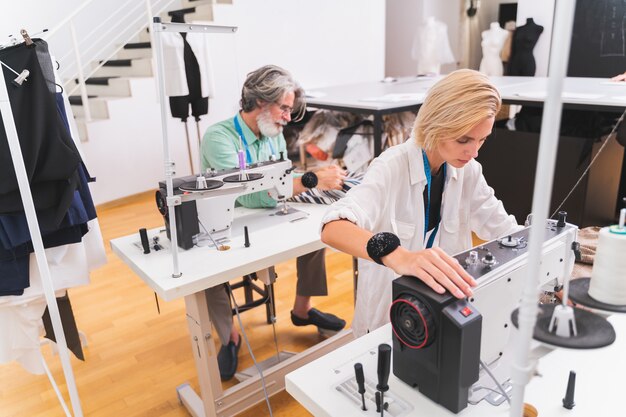 Equipe multiétnica de designers de moda trabalhando em uma oficina de criação de roupas - Grupo multirracial de estilistas, estilistas e costureiras trabalhando em uma nova coleção