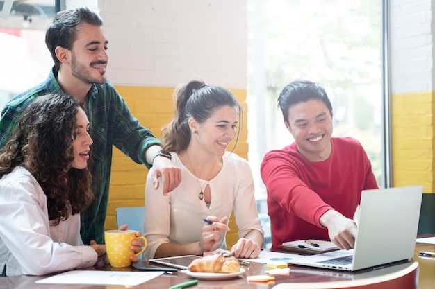 Equipe multiétnica de jovens colegas de trabalho planejando uma nova startup Pessoas felizes trabalhando em um novo projeto no escritório de coworking criativo Conceito de marketing Filtro brilhante com foco no rosto da mulher no centro