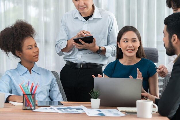 Equipe multirracial de analistas usa dados do painel de BI para analisar relatórios financeiros na mesa de reunião Grupo de diversos empresários utiliza análise de dados da FIntech para decisões de marketing de negócios Concord