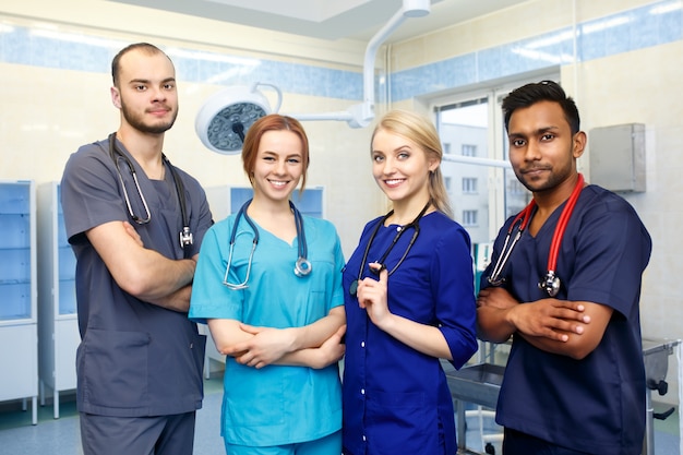 Foto equipe multirracial de jovens médicos em um hospital em pé na sala de cirurgia