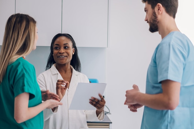 Foto equipe multirracial de médicos discutindo a condição de um paciente enquanto trabalhava em um hospital