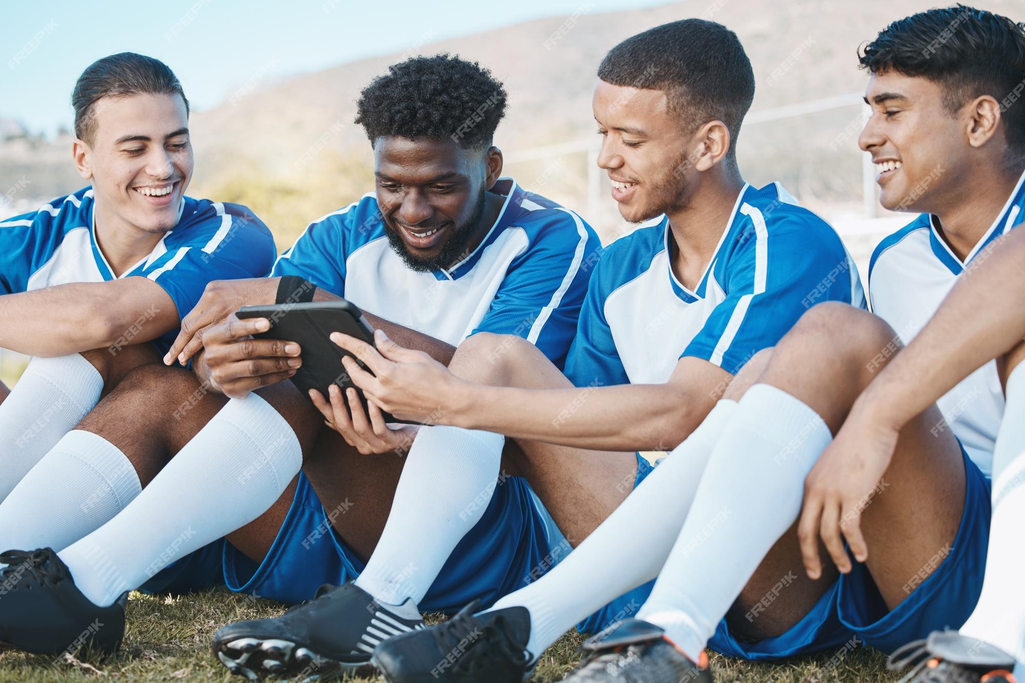 Equipe ou grupo de jogadores de futebol com um tablet ao ar livre em campo  para treinamento físico ou jogo online clube de futebol e atletas de  diversidade ou amigos com tecnologia para assistir a competições esportivas  ou vídeos