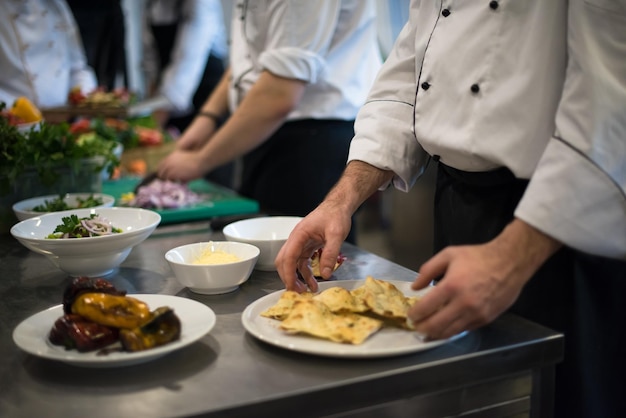 Equipe profissional de cozinheiros e chefs preparando a refeição em um hotel movimentado ou cozinha de restaurante