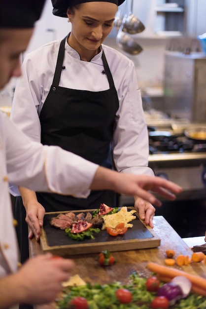 Equipe profissional de cozinheiros e chefs preparando a refeição em um hotel movimentado ou cozinha de restaurante