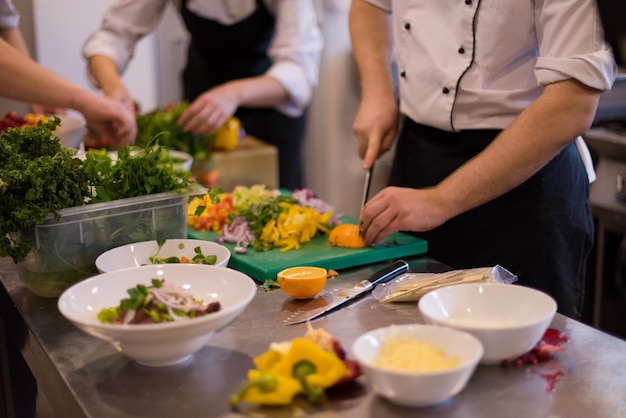 Equipe profissional de cozinheiros e chefs preparando a refeição em um hotel movimentado ou cozinha de restaurante