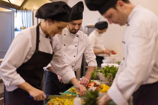 Equipe profissional de cozinheiros e chefs preparando a refeição em um hotel movimentado ou cozinha de restaurante