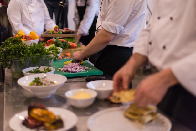 Equipe profissional de cozinheiros e chefs preparando a refeição em um hotel movimentado ou cozinha de restaurante