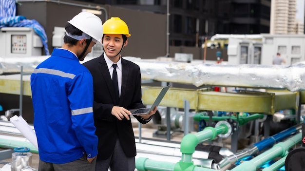 Equipe profissional homem de negócios asiático jovem CEO e engenheiro de energia planeja um projeto para construir um painel solar para o edifício em construção conceito de energia alternativa limpa e verde