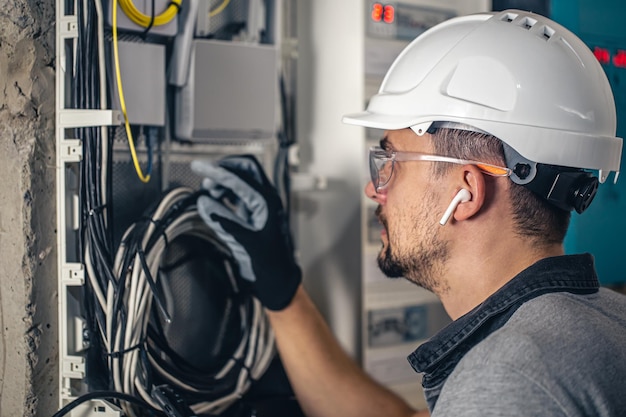 Equipe um técnico elétrico trabalhando em um quadro de distribuição com fusíveis