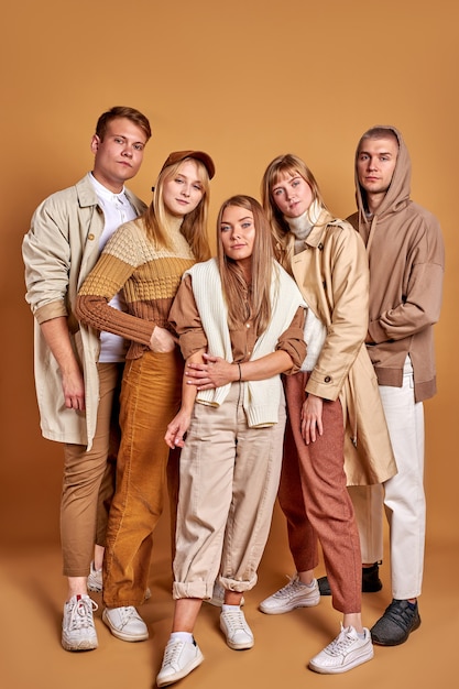 Foto equipe unida de jovens posando com roupas da moda em tons pastel