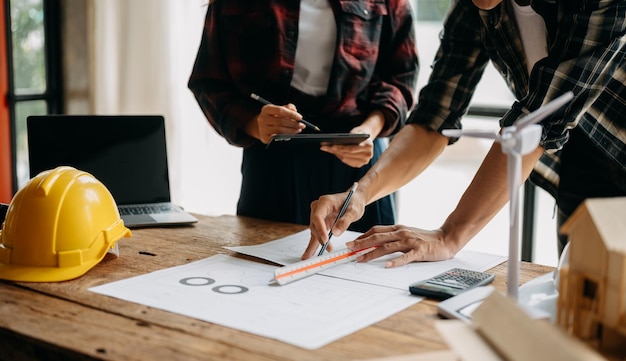 Equipes de engenheiros que se reúnem trabalhando juntas usam capacetes de trabalhador no canteiro de obras na cidade modernaequipe profissional da indústria asiática