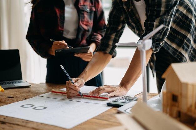 Equipes de engenheiros que se reúnem trabalhando juntas usam capacetes de trabalhador no canteiro de obras na cidade modernaequipe profissional da indústria asiática