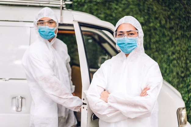 Equipes profissionais para trabalhador de desinfecção em máscara protetora e vírus de limpeza de spray desinfetante de traje branco para ajudar o serviço a matar o coronavírus na casa do cliente