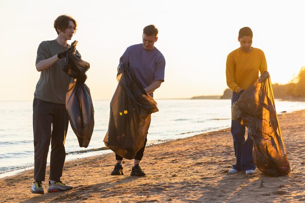 El equipo de activistas voluntarios del Día de la Tierra recoge basura limpiando la playa de la zona costera con mujeres