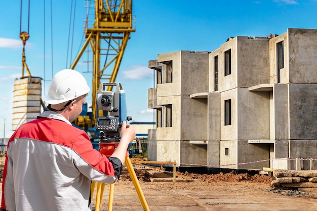 Equipo de agrimensor El telescopio de agrimensor en el sitio de construcción o Agrimensura para hacer planos de contorno es una representación gráfica de la disposición del trabajo de construcción de puesta en marcha del terreno