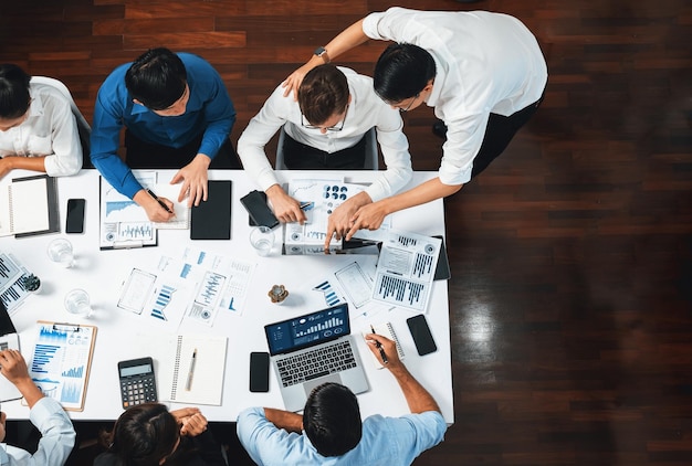 Equipo de analistas de vista superior utilizando BI Fintech para analizar datos financieros en la mesa en la sala de reuniones Panel de control analítico de BI poder en papel para la visión empresarial y la planificación estratégica de marketing Prudent