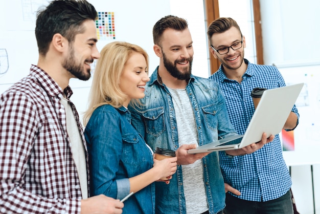 El equipo de arquitectos de los diseñadores mira la computadora portátil.