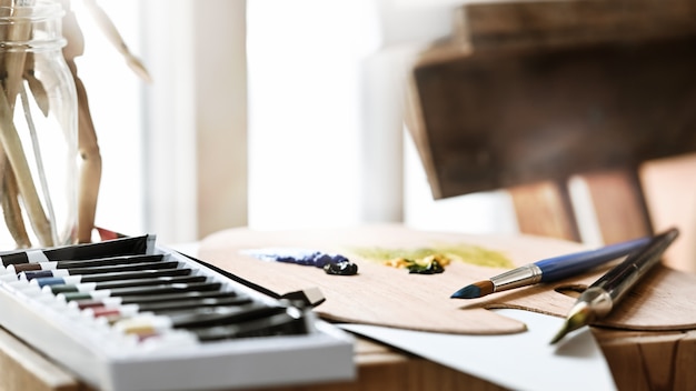 Equipo del artista que pone en la mesa de trabajo de madera.