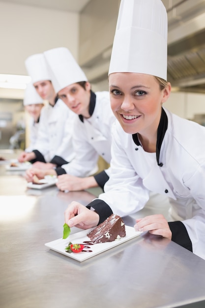 El equipo del chef prepara rebanadas de pastel