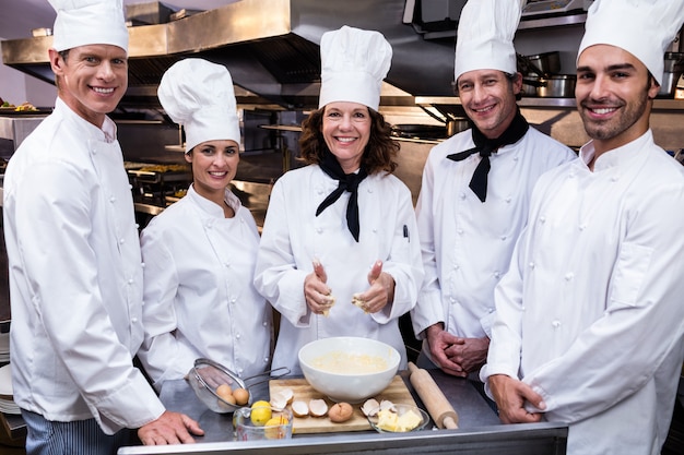 Equipo de chefs sonriendo en cocina comercial