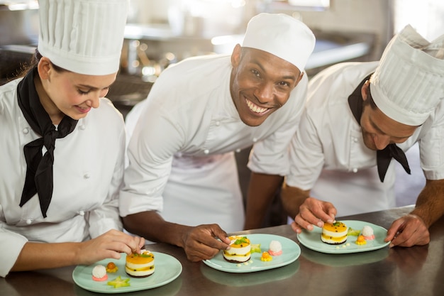 Equipo de chefs terminando platos de postre