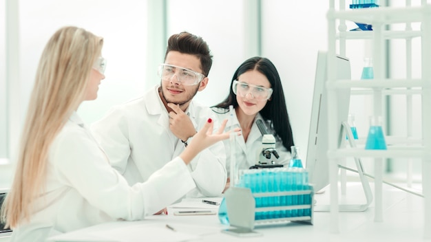 equipo de científicos discutiendo algo en el escritorio.