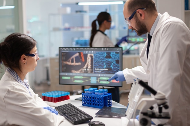 Foto equipo de científicos de microbiología discutiendo sobre el desarrollo de vacunas en un moderno laboratorio equipado