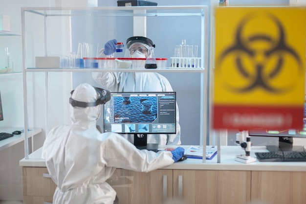 Equipo de científicos que trabajan para desarrollar un tratamiento para virus en laboratorio con traje de ppe