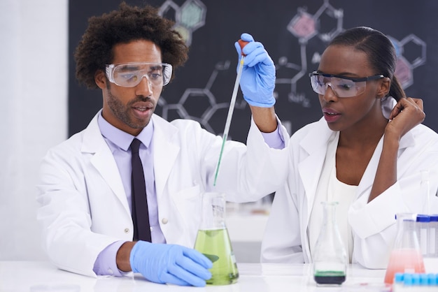 Equipo de científicos y químicos en un vaso para el experimento científico con investigación médica en laboratorio Química farmacia y innovación sanitaria con pruebas de vacunas personas negras y solución líquida