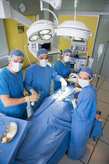 Equipo de cirugía mirando la cámara durante la operación.