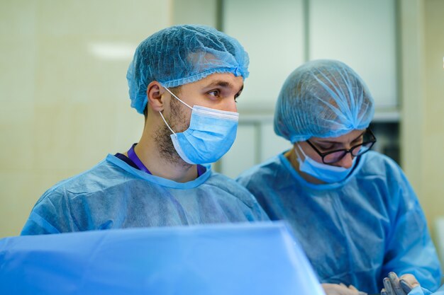Foto equipo de cirujanos que realizan la operación en la sala de cirugía moderna y luminosa. quirófano. equipo moderno en clínica. sala de emergencias.