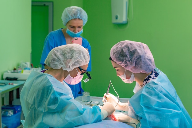 Equipo de cirujanos trabajando con el paciente. aumento de senos