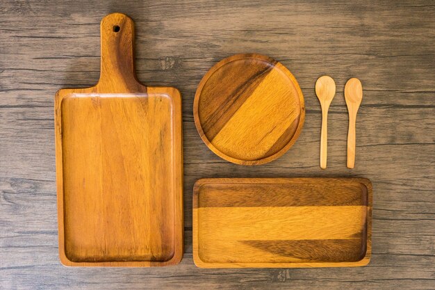 Equipo de cocina de madera para alimentos y puesto al horno en mesa de madera.