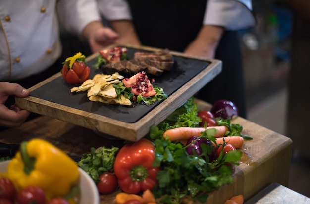 Equipo de cocineros y chefs profesionales que preparan la comida en la concurrida cocina de un hotel o restaurante