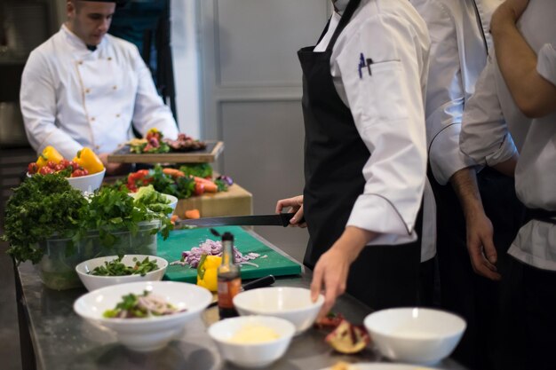 Equipo de cocineros y chefs profesionales que preparan la comida en la concurrida cocina de un hotel o restaurante