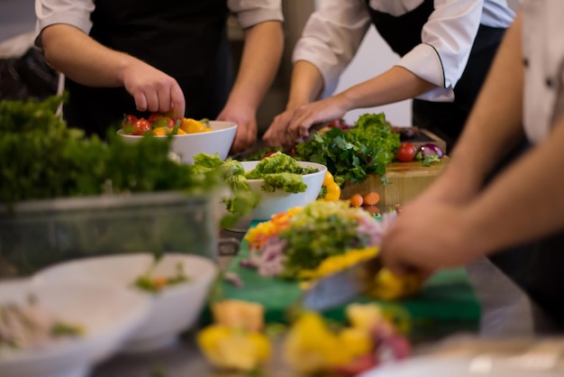 Equipo de cocineros y chefs profesionales que preparan la comida en la concurrida cocina de un hotel o restaurante