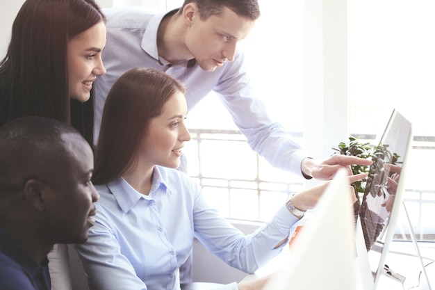 Foto equipo de colegas intercambiando ideas juntos mientras trabajan en la computadora