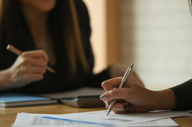 El equipo contable femenino está analizando los datos para resumir el presupuesto.