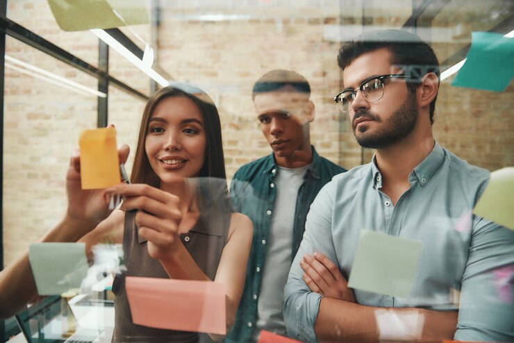 Foto equipo creativo, colegas masculinos y femeninos inteligentes que planifican el proceso de trabajo y usan tarjetas de notas mientras