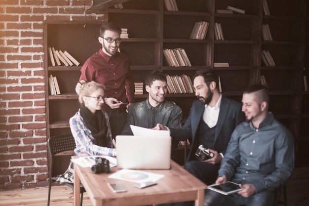 Equipo creativo positivo de redactores publicitarios en el lugar de trabajo en una oficina moderna