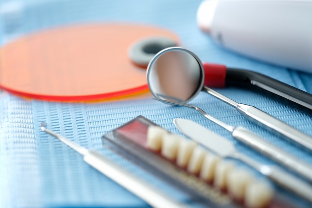 El equipo dental se encuentra en una servilleta azul sobre la mesa en la oficina del dentista closeup antecedentes