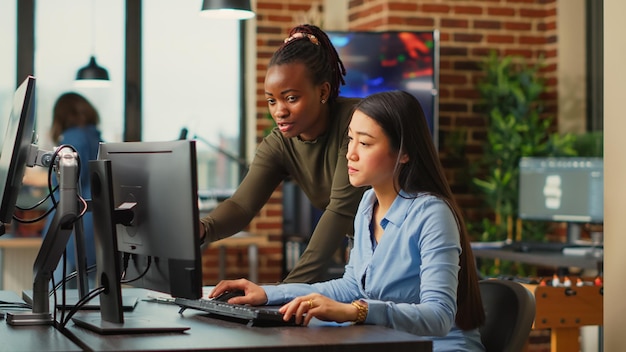 El equipo del departamento de producción realiza una lluvia de ideas para crear contenido artístico en línea, utilizando habilidades creativas e inteligencia artificial. Mujeres que trabajan en el desarrollo de aplicaciones o juegos, trabajo profesional.