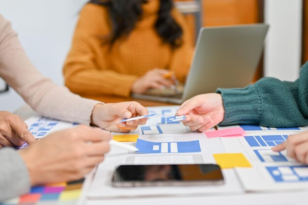 Un equipo de desarrolladores de aplicaciones móviles está discutiendo y compartiendo sus ideas en la reunión.