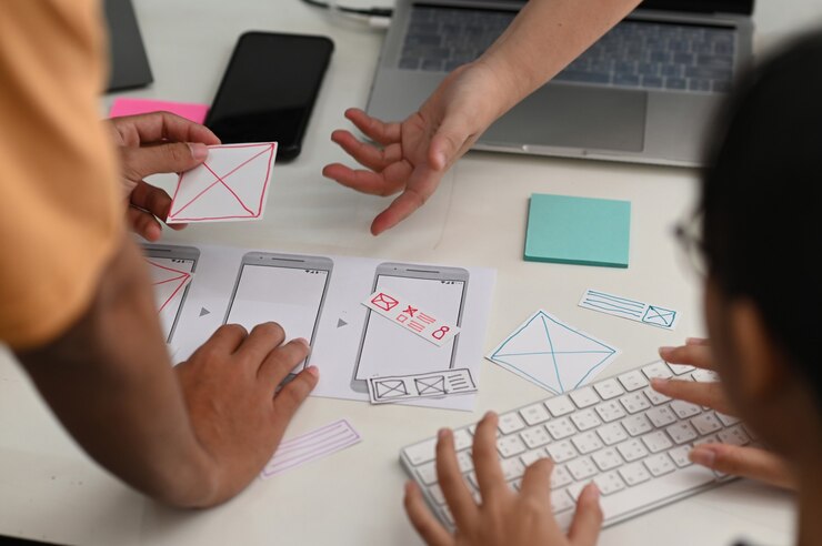 Foto equipo de diseñadores de aplicaciones para teléfonos inteligentes que trabajan juntos para diseñar un nuevo proyecto