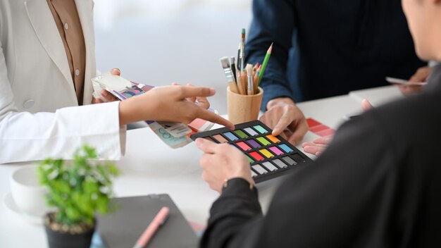 El equipo de diseñadores está trabajando juntos en la oficina para discutir sobre el color de su proyecto