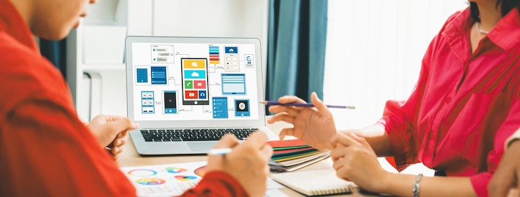 Foto el equipo de diseñadores presenta color mientras el portátil muestra diseños de interfaz de usuario y ux variados