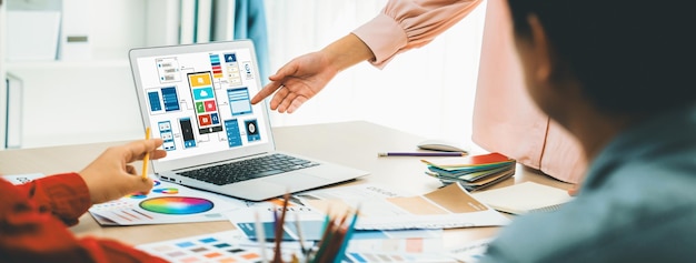 Foto el equipo de diseñadores presenta el color mientras que el portátil muestra los diseños de ui y ux variegated.